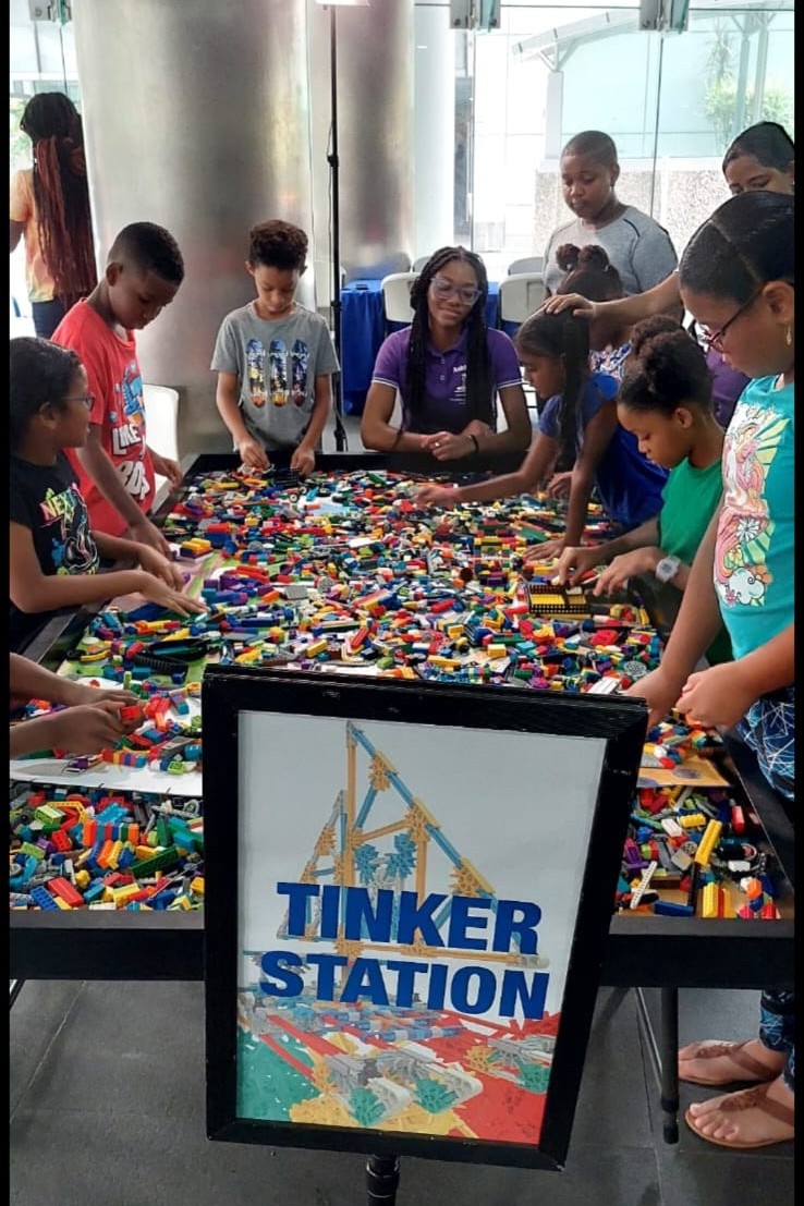 Kids at a Tinker Station building with Legos